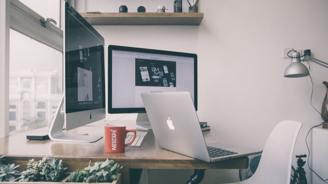 A tidy home office desk with a laptop and monitor